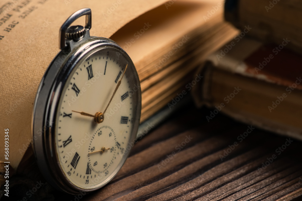 Naklejka premium Old vintage watch on books background close up