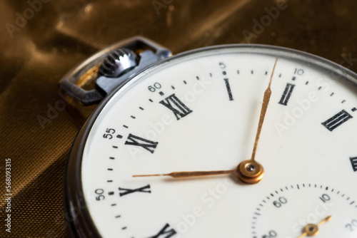 Old pocket watch on golden background close up