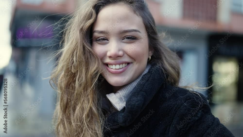 Young beautiful hispanic woman smiling confident combing hair with hands at street Young beautiful hispanic woman smiling confident combing hair with hands at street
