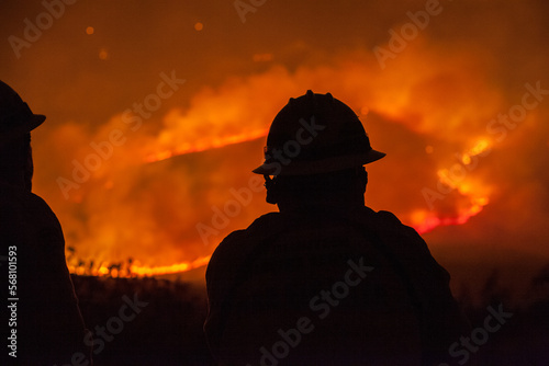 Silhouetted Firefighter Surveying Wildfire