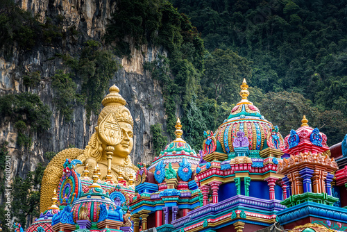 Photography Colorful Saints and a golden Buddha in front of  the Batu Caves, Kuala Lumpur, M