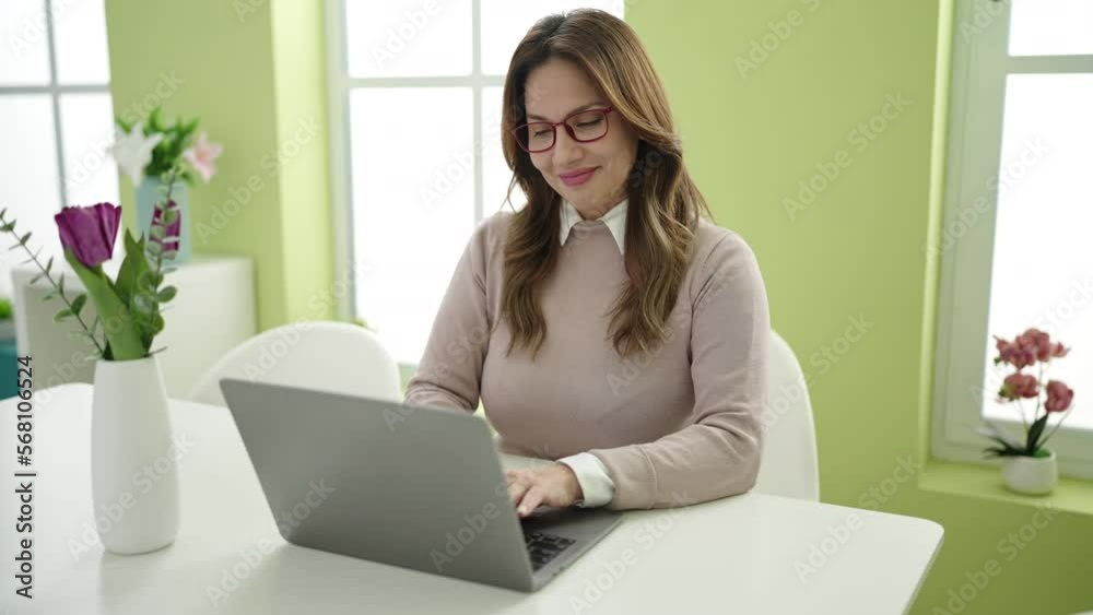 Young beautiful hispanic woman using laptop sitting on table at home Young beautiful hispanic woman using laptop sitting on table at home
