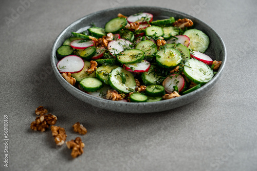 fresh vegetable salad of radish cucumbers and walnuts. green spring salad