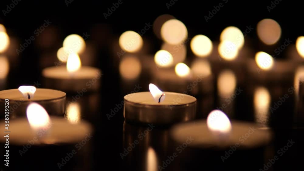 Many candles burn in the dark. Memorial day with candles. Lighted memorial candles. Funeral candles close-up. Many candles burn in the dark. Memorial day with candles. Lighted memorial candles. Funeral candles close-up.