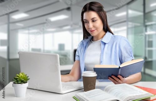 Happy young woman in office work with laptop