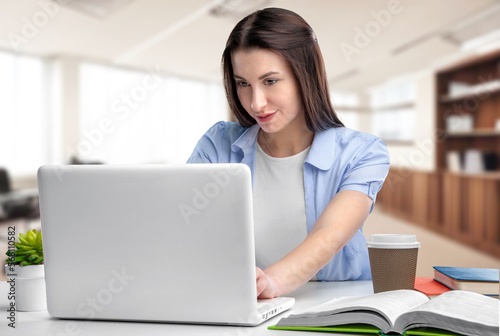 Happy young woman in office work with laptop