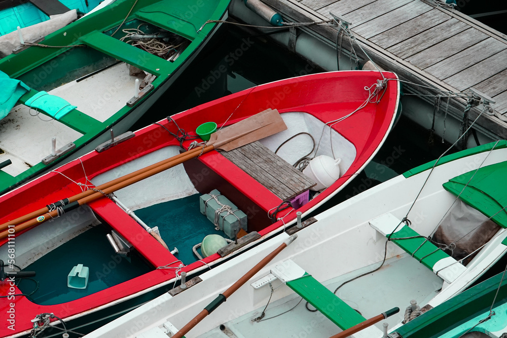 Des barques rouge verte et blanche amarrées à un ponton