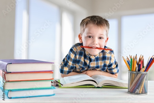 Cute small school child studying at class