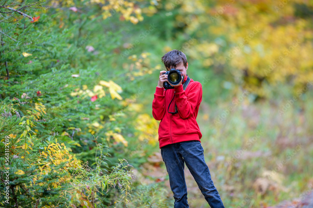 Boy in red shirt taking photo with camera Boy in red shirt taking photo with camera