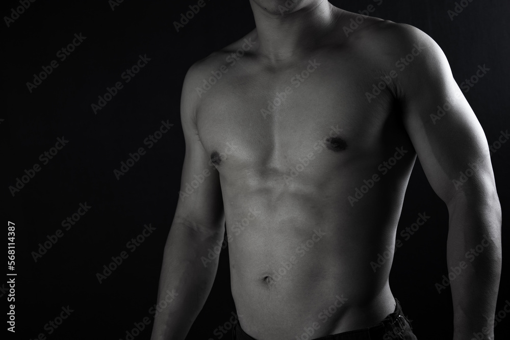 Close up view of sexy body of young man with six pack muscular and athletic body on black background. concept of health care, exercise, fitness, muscle mass, health supplements. Close up view of sexy body of young man with six pack muscular and athletic body on black background. concept of health care, exercise, fitness, muscle mass, health supplements.