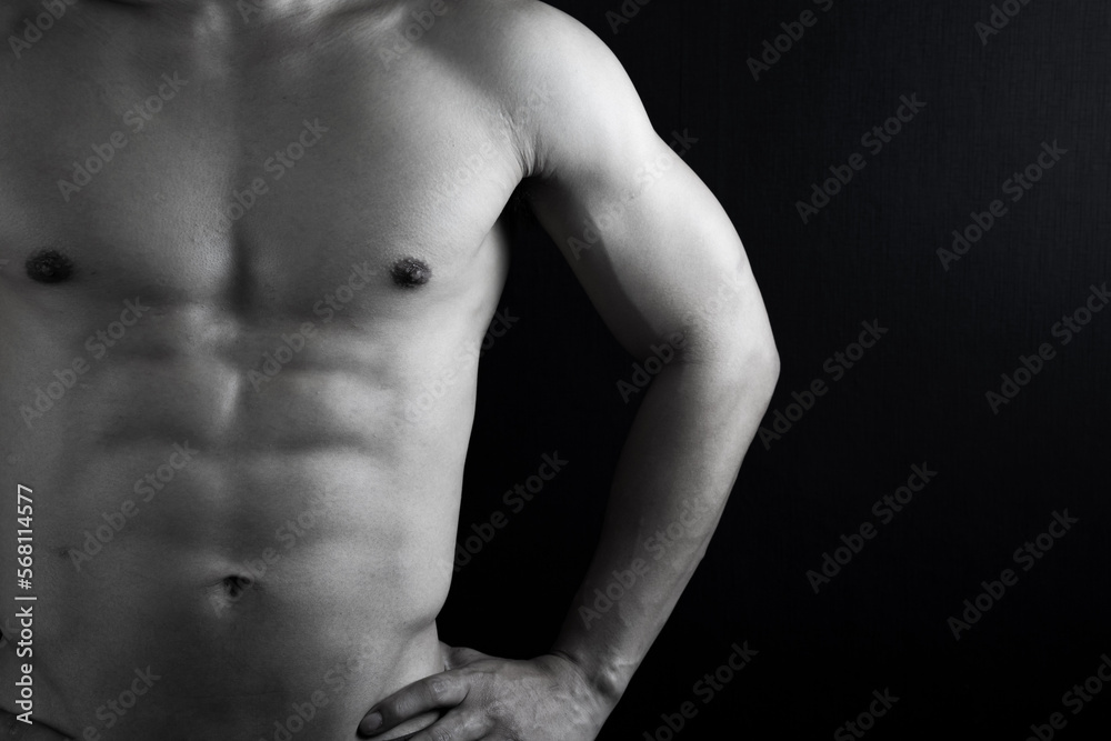 Fototapeta premium Close up view of sexy body of young man with six pack muscular and athletic body on black background. concept of health care, exercise, fitness, muscle mass, health supplements.