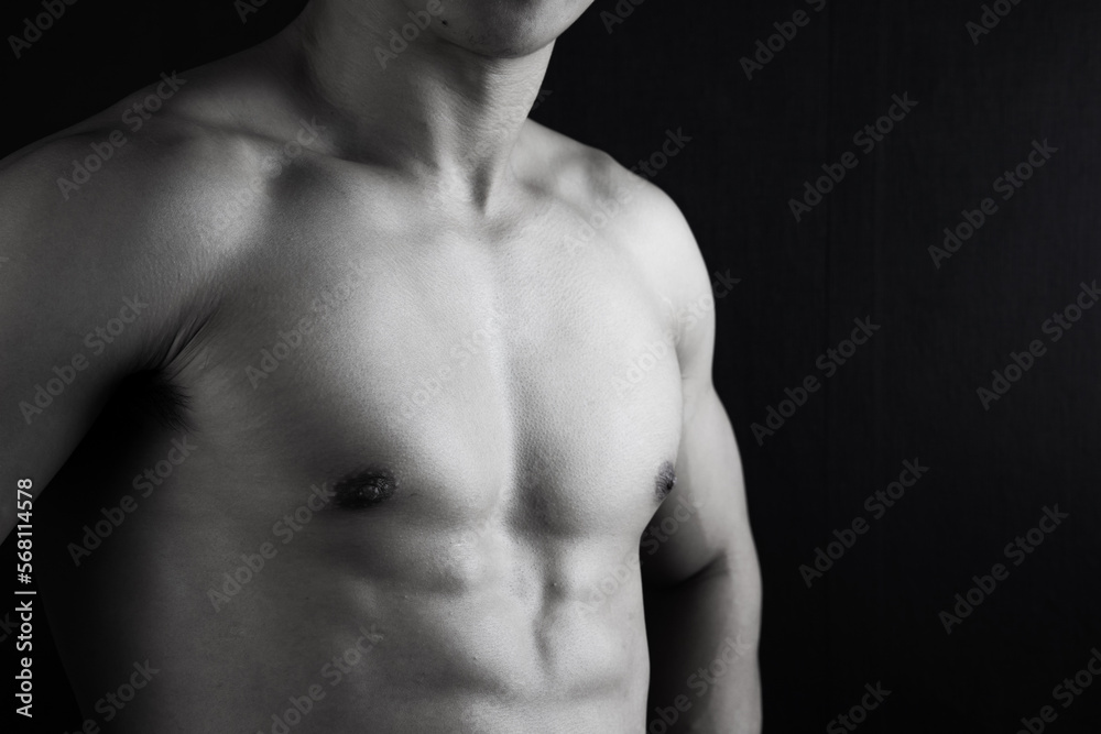 Close up view of sexy body of young man with six pack muscular and athletic body on black background. concept of health care, exercise, fitness, muscle mass, health supplements. Close up view of sexy body of young man with six pack muscular and athletic body on black background. concept of health care, exercise, fitness, muscle mass, health supplements.