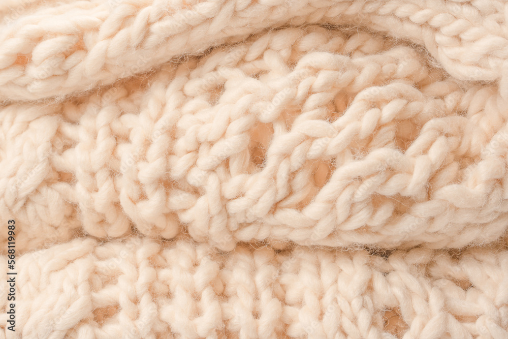 A fragment of beige knitted fabric, knitted from white sheep wool. A fragment of beige knitted fabric, knitted from white sheep wool.