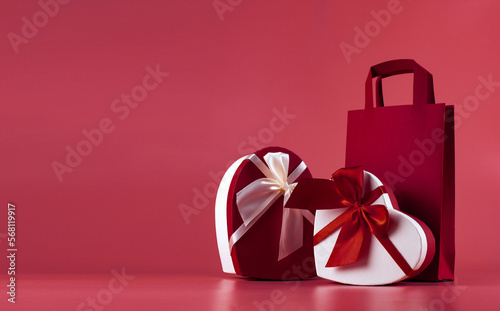 Banner with a gift box in the shape of a heart on a red background. Valentine's Day gift concept, wide banner with space for text. Concept - promotion, sale, shopping.