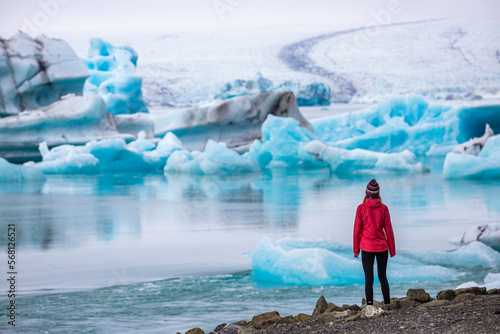 A girl wearing an Icelandic wool cap admires the unique blue icebergs on Lake Jökulsárlón, a unique glacial lake at the Vatnajökull glacier