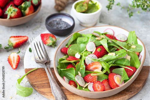 Spinach salad with strawberries, almond and poppy.