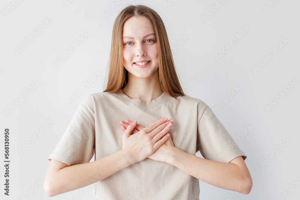 hopeful young woman holding hands on chest hopeful young woman holding hands on chest