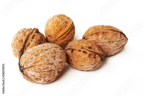 Walnuts in shell isolated on white background. A pile of delicious and healthy whole walnuts, isolated on a white background. Healthy food concept. 