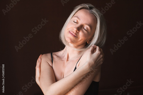 Attractive middle-aged woman enjoys herself and her body, loves herself
