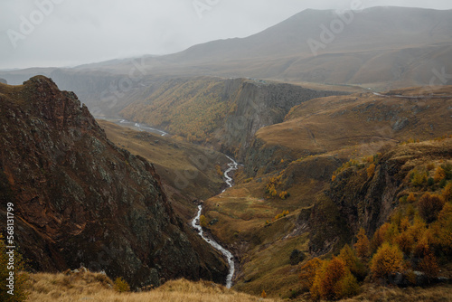 Photo of the gorge with mount river in it in Autumn foggy and cloudy day. Photo taken on Djily-Su road  it s popular tourist place in Kabardino-Balkaria  Russia