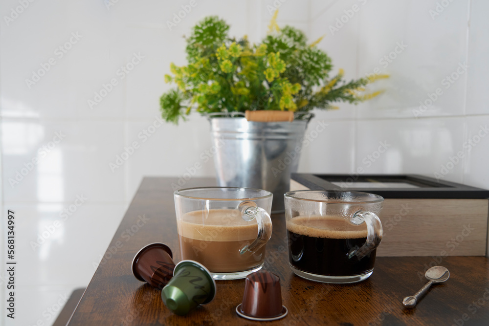 Coffee with milk and black coffee from capsules on brown wooden table