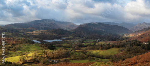 Stunning Winter sunrise golden hour landscape view from Loughrigg Fell across the countryside towards Langdale Pikes in the Lake District