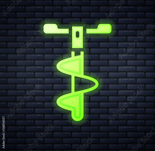 Glowing neon Hand ice drill for winter fishing icon isolated on brick wall background. Vector