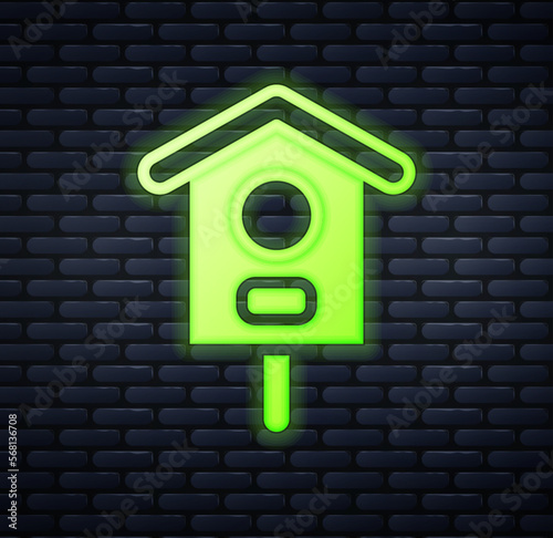 Glowing neon Bird house icon isolated on brick wall background. Nesting box birdhouse, homemade building for birds. Vector