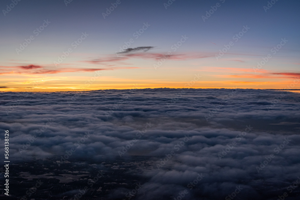 Beautiful sunset above the clouds over the city of Amsterdam, the Netherlands
