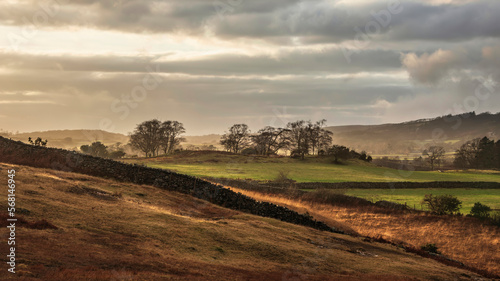 Stunning Winter sunset golden hour landscape image of view from Wast Water over countryside in Lake District towards the Western district