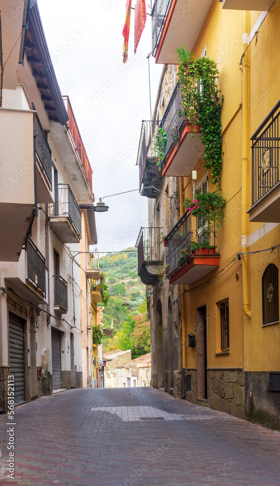 beautiful narrow medeterranean street with vintage buildings , beautiful windows and picturesque balcony with attributes of traditional italian country life
