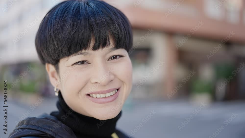 Young chinese woman smiling confident standing at street Young chinese woman smiling confident standing at street
