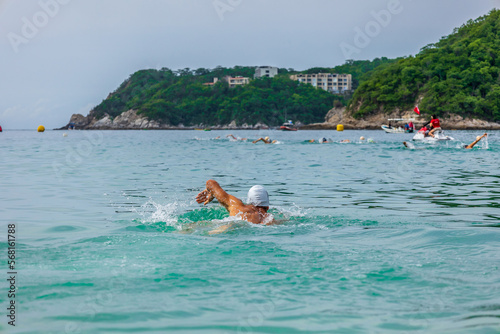 Triathlete starting the swim in the Huatulco bay - Mexico. Open water swimmer on the ocean