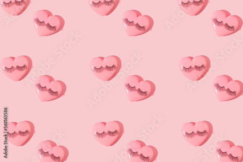 Valentines day creative pattern with baby pink hearts and false eyelashes on pastel pink background. 80s or 90s retro fashion aesthetic love concept. Minimal romantic idea.