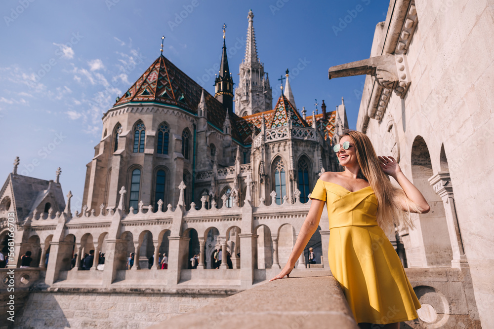 Happy woman tourist walking near Matthias Roman Catholic Church and Fisherman's Bastion in Budapest, Hungary