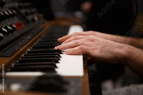 Hands of pianist playing music on synthesizer. Professional synth device keyboard in close up