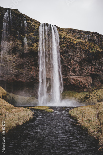 Waterfall landscape in Iceland in October with brown green colors and black earth