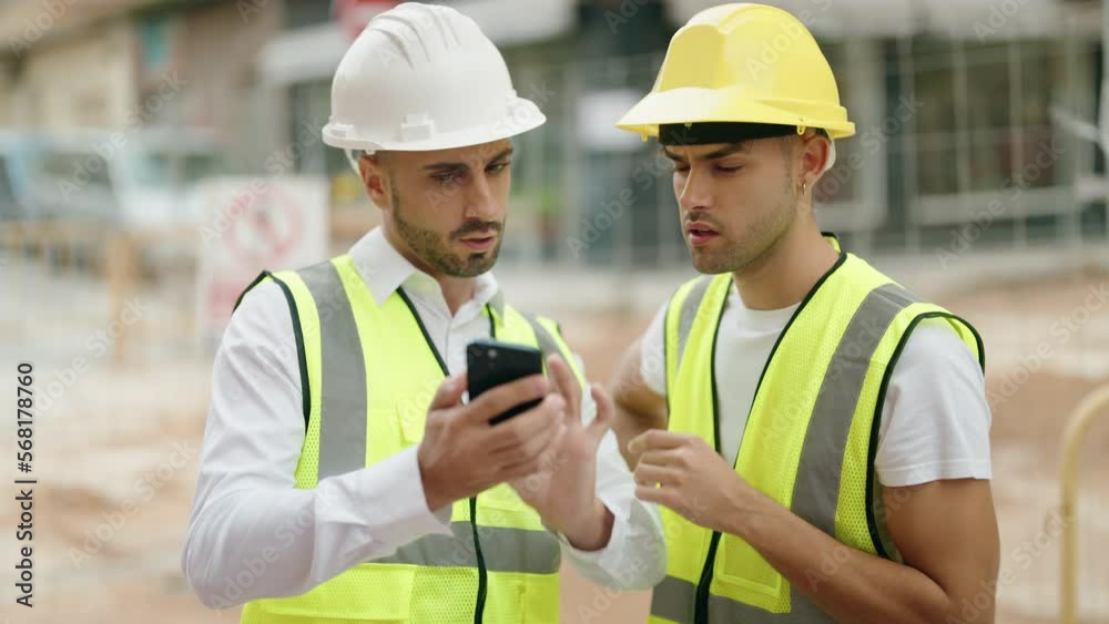 Two hispanic men architects using smartphone speaking at street Two hispanic men architects using smartphone speaking at street