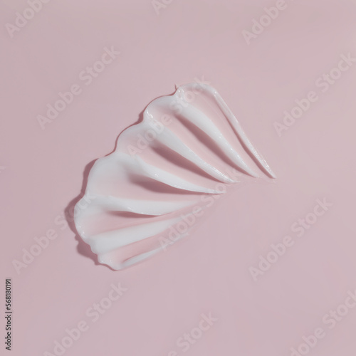 White beauty cream smear smudge on pink background. Cosmetic skincare product texture. Face cream, body lotion swipe swatch
