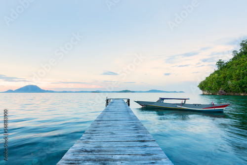 Old wooden dock at the lake with traditional boat, sunset shot