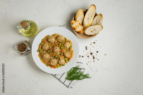 Plate of meatballs in gravy with vegetbales