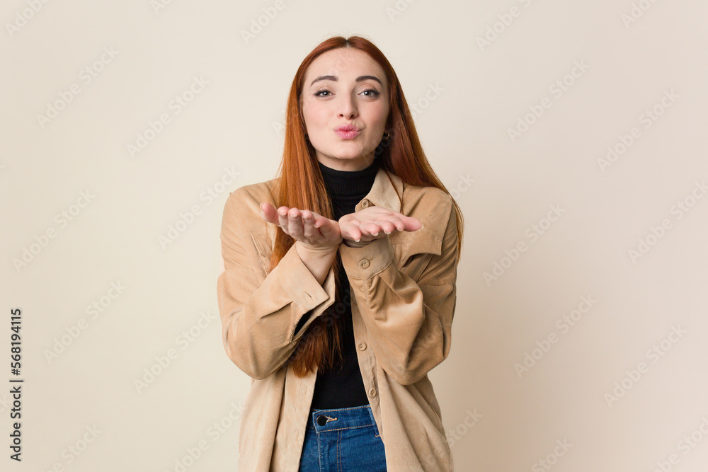 Young red hair woman isolated folding lips and holding palms to send air kiss.