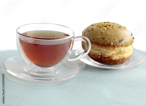 cup of hot tea and cake doughnut close up photo