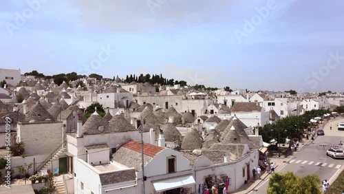 Aerial drone footage of Alberobello, Puglia, Italy. Establish scene of the traditional whitewashed, conical roof (trulli) UNESCO world heritage site, landmark tourist destination from above.