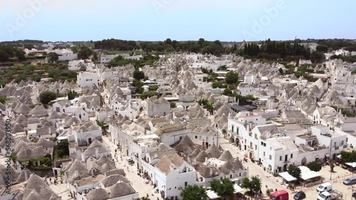 Aerial drone footage of Alberobello, Puglia, Italy. Establish scene of main streets, traditional whitewashed, conical roof (trulli) UNESCO world heritage site, landmark tourist destination from above