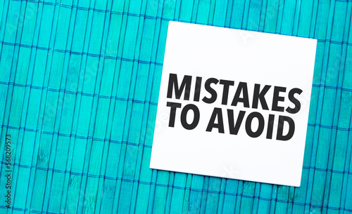 Mistakes To Avoid word on torn paper with blue wooden background