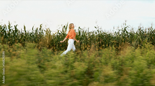 Fototapeta Naklejka Na Ścianę i Meble -  Healthy Lifestyle Concept. Young Pretty Caucasian Happy Girl Woman Run At Cornfield Summertime. Focus And Concentration Concept. Managing Stress. Daily Calm.