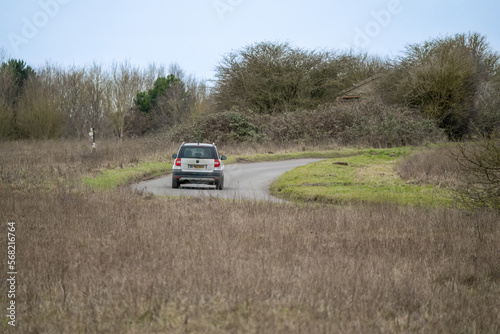 silver Skoda yeti motor car driving around a bend in the road on a country lane across Salisbury Plain © Martin