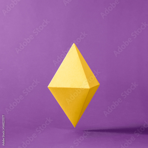 The symbol of the decentralized virtual digital currency Ethereum on a purple background in levitation. High quality photo