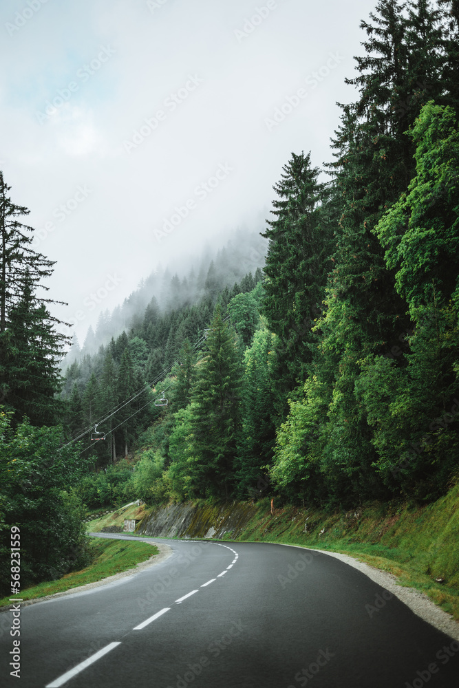 Empty road with a gondola and heavy clouds on the trees nearby Châtel, France Empty road with a gondola and heavy clouds on the trees nearby Châtel, France